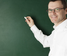 male teacher writing on a blackboard