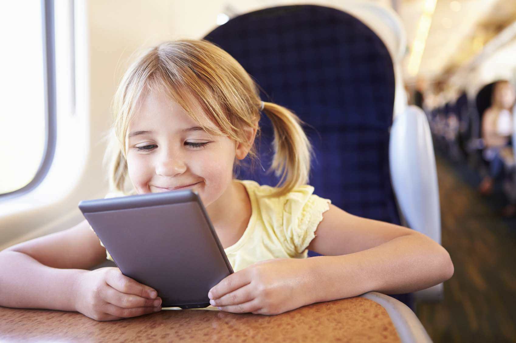 Young girl using tablet on the train