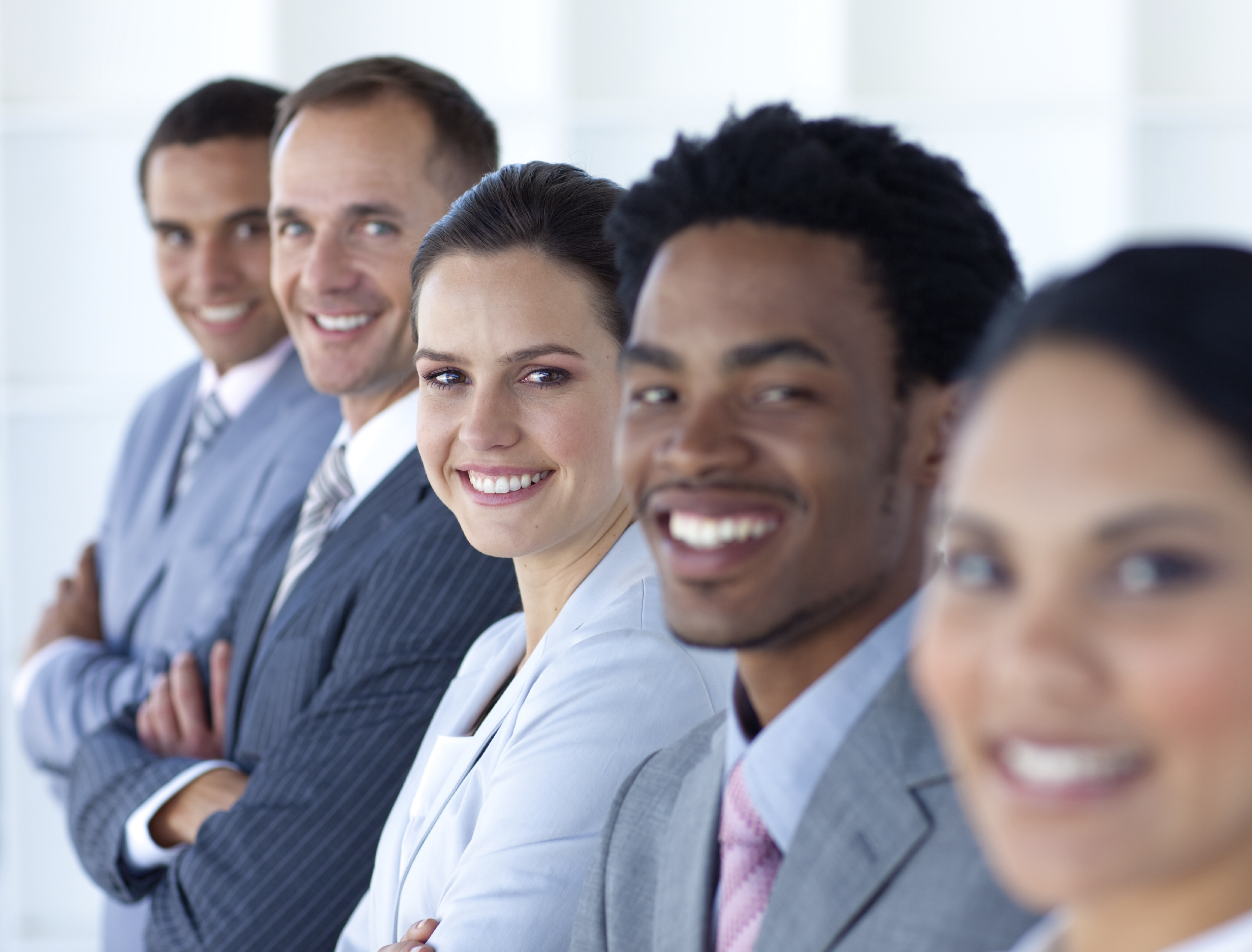 Team of five employees, confidently smiling
